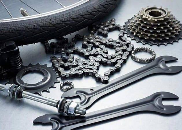 a bicycle tire, wrenches, gears, and a bike chain